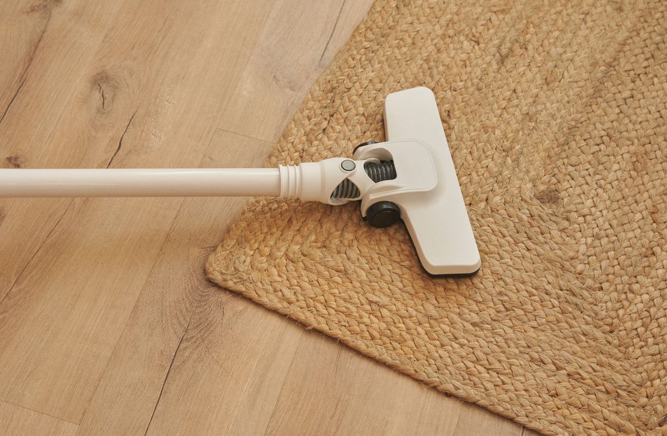A vacuum cleaner resting on a wooden floor, highlighting a rug cleaning service based in Jacksonville, FL.